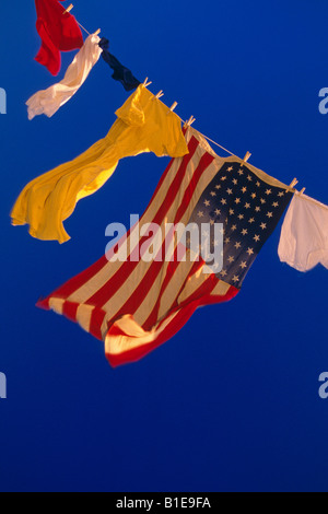 US Flag et uniformes sur la ligne de vêtements dans le vent contre le ciel bleu USA Banque D'Images