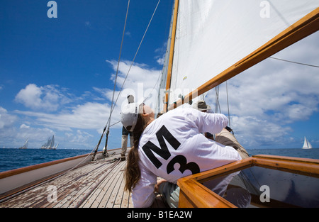 Un membre de l'équipe cherche à contrôler la voile à bord du yacht à Galatée pendant les courses de Antigua Banque D'Images