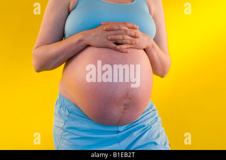 Vue sur le ventre de femme enceinte comme mari se tient derrière elle avec ses mains liées sur son estomac Alaska United States Banque D'Images