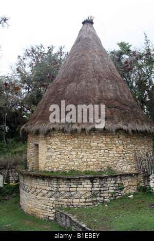 Une maison au toit de chaume et pierre retored à ruines de la ville de Chachapoyan Kuelap dans les hautes terres du nord du Pérou. Banque D'Images