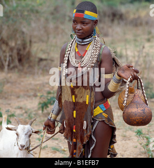 Une jolie femme Hamar dirige une chèvre à vendre à Dimeka, le plus grand marché de l'Hamar pays de sud-ouest de l'Éthiopie. Banque D'Images