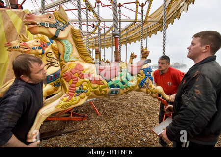 Les travailleurs forains assembler gallopers pour Owen Smith and Son's Carousel sur le front de mer de Brighton prêt pour la nouvelle saison Banque D'Images