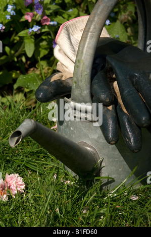 Arrosoir et des gants de jardinage close up in garden England UK Royaume-Uni GB Grande Bretagne Banque D'Images