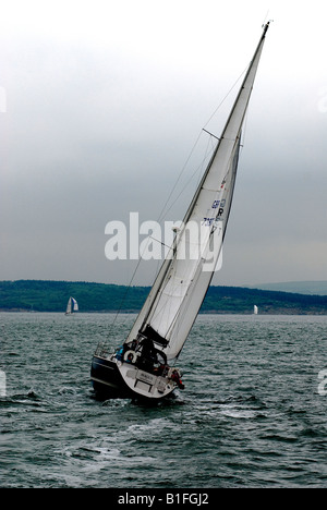 Bateau à voile virant sur le Solent à l'égard de l'île de Wight Banque D'Images