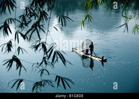 Li River près de Xingping avec fisherman à travers feuilles de bambou de l'aviron sur radeau en bambou, Guilin/Yangshuo Domaine du Guangxi Banque D'Images