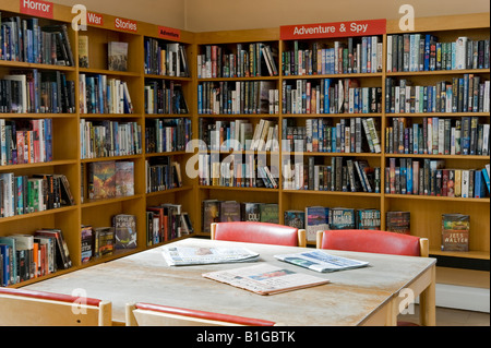 Intérieur de la bibliothèque, ressources et installations communautaires (chaises, journaux sur tables, bibliothèques, étagères de livres) - Baildon, Yorkshire, Angleterre, Royaume-Uni. Banque D'Images