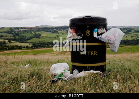 Close-up de la poubelle dans la campagne débordant de détritus dans le besoin d'être vidée. Banque D'Images