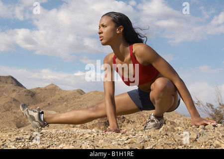 Female jogger stretching en montagne Banque D'Images