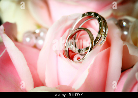 Closeup détail des bandes de mariage mariage gravée sur bouquet de fleurs rose rose mariage mariage image carte de vœux Banque D'Images