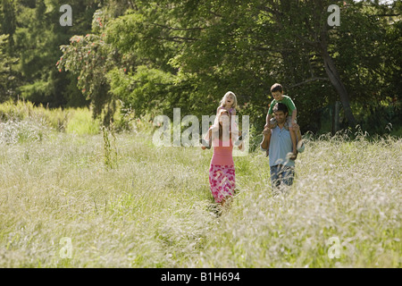 Une famille de marcher à travers un champ Banque D'Images