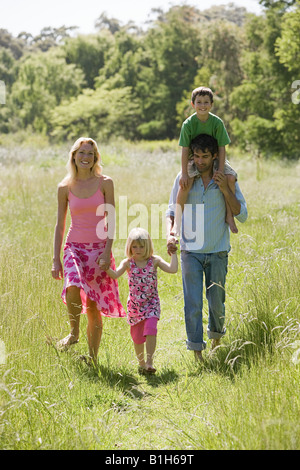 Une famille de marcher à travers un champ Banque D'Images