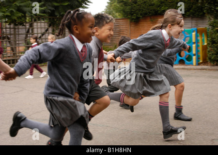 Groupe d'enfants qui courent dans l'aire d'une école privée Banque D'Images