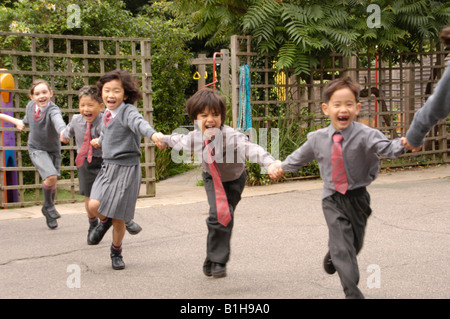 Les enfants dans l'aire d'une école privée et tenir la main courante Banque D'Images