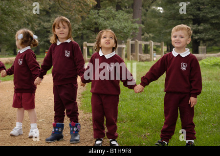 Les enfants de l'école dans un parc permanent holding hands Banque D'Images