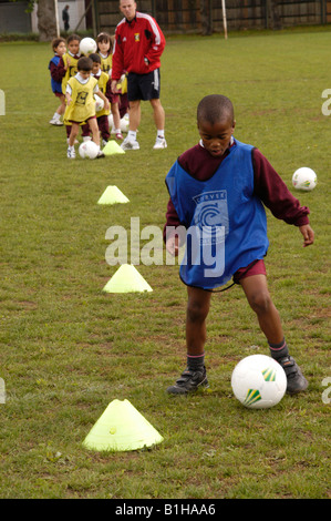 Balle d'entraînement de football en boydribbling Banque D'Images