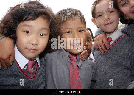 Groupe d'enfants smiling at the camera in school uniforms Banque D'Images