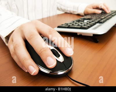 Businesswoman typing dans le clavier de l'ordinateur et l'utilisation d'une souris Banque D'Images