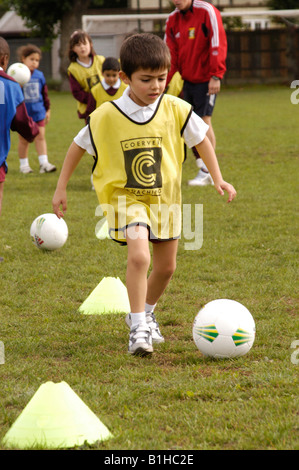 Le football dribble garçon dans la formation Banque D'Images