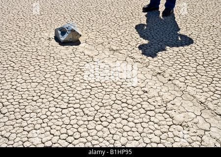 Un rock coulissante et l'homme sur la piste de Playa dans une partie reculée de la Death Valley National Park Californie USA. Banque D'Images