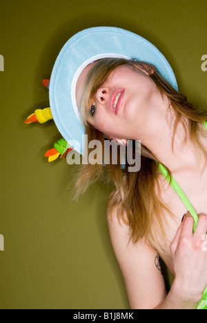 Jeune femme portant un chapeau comme un gâteau d'anniversaire Banque D'Images