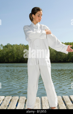 Young Pretty woman practicing Tai Chi sur une promenade au bord d'un lac, le yin-yang-meridian meridian, Banque D'Images