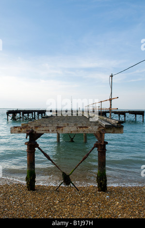 Et battues broken old pier surplombant la mer une fois utilisé comme partie d'un ancien chantier naval pour le ravitaillement en carburant Banque D'Images