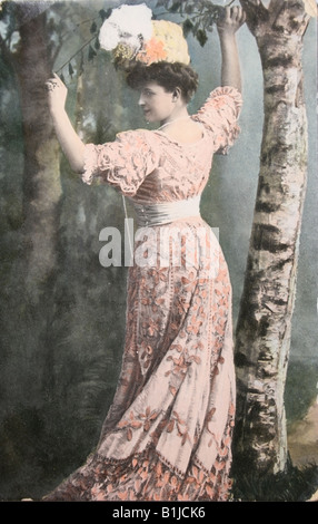 Carte postale vintage avec photographie de peinte à la belle dame en robe a la mode de 1910 Banque D'Images