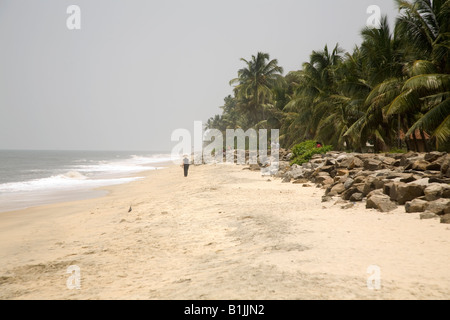 Une femme marche le long de la plage Alappuzha palmiers au Kerala, en Inde. Banque D'Images