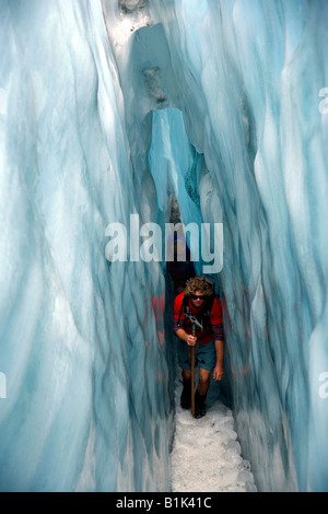 Homme marchant à travers la glace tunnel à Franz Josef Glacier sur l'île du sud de la Nouvelle-Zélande Banque D'Images