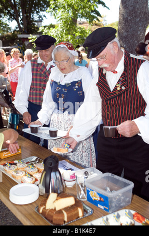 Les personnes âgées en robe folk traditionnel servant eux-mêmes at garden party en Suède La Suède Sweden Öckerö Banque D'Images