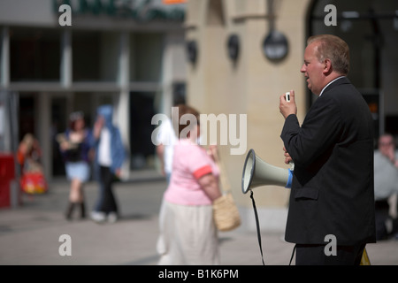 Prédicateur fondamentaliste chrétien avec microphone et haut-parleur de l'après-midi ensoleillée dans la prédication principale zone commerçante belfast Banque D'Images