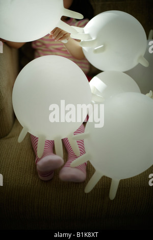 Avec pas de ballons dans la chambre fille âgée de quatre ans joue avec des gants en latex blanc gonflé Banque D'Images