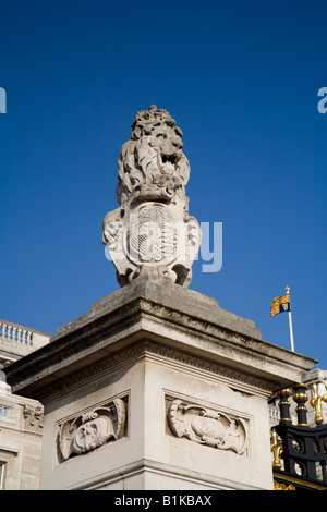 Détail de la limite du palais de Buckingham un lion tenant les armoiries royales avec le royal standard flying Banque D'Images