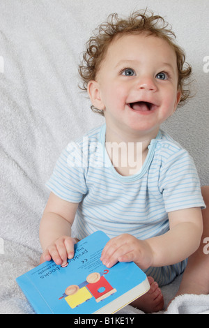 Little baby holding photo book Banque D'Images