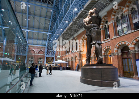 Les amoureux enlacés sur Paul Jours sculpture "le lieu de rencontre" dans le grand hall de la gare St Pancras Banque D'Images