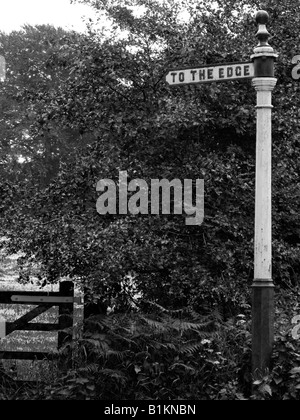 Ancien fer à repasser sign post disant À LA PÉRIPHÉRIE. À Wilmslow, Cheshire, près de Manchester. Photographie en noir et blanc. Monochrome. Banque D'Images