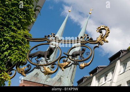 Enseigne en fer forgé médiéval avec les clochers de l'église Saint-Nicolas en arrière-plan Mitte Berlin Allemagne quartier Scheunenviertel Banque D'Images