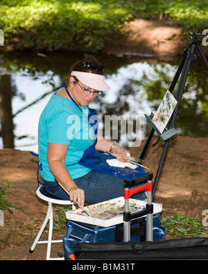 Une femme de race blanche dans la cinquantaine peint un paysage photo sur l'emplacement à un parc. Oklahoma City, Oklahoma, USA Banque D'Images