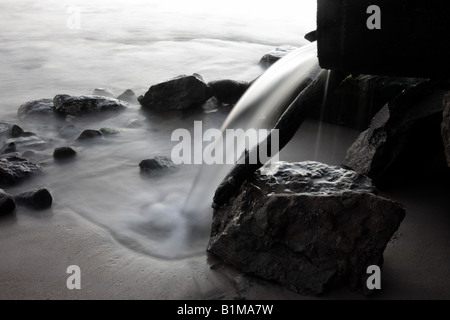 Vidange Assainissement de l'eau qui s'écoule à l'OCÉAN PAR ROCKS BDA HORIZONTALE11120 Banque D'Images