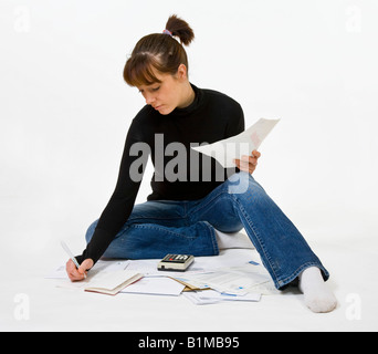 Femme, 20 ans, assise sur le sol entouré de factures. Banque D'Images