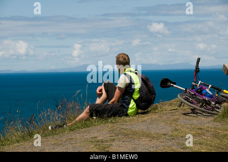 Cycliste sur le chemin Côte Ceredigion sentier du littoral à l'échelle du Nord La Baie de Cardigan , après-midi d'été Banque D'Images