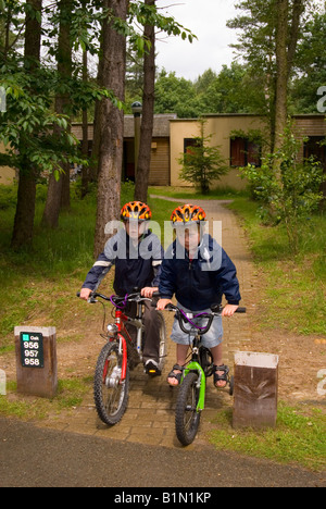 Les jeunes garçons à l'extérieur de Villa sur vélo à Center Parcs à Elveden près de Thetford,UK Banque D'Images