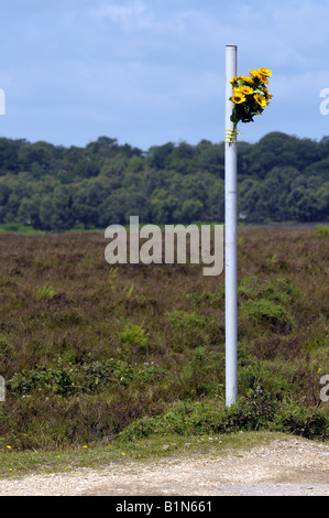 Un bouquet de tournesols artificiels liés à un poste en bordure d'un culte à une personne tuée dans un accident de voiture Banque D'Images