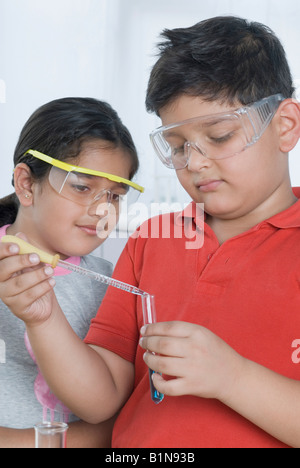 Garçon et une fille faire expérience scientifique dans un laboratoire Banque D'Images