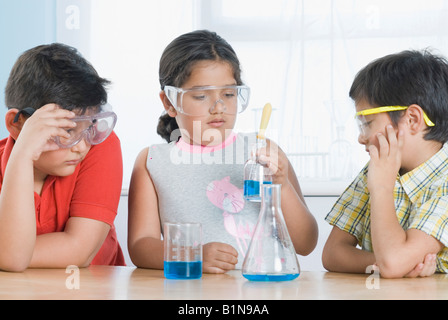 Fille avec d'autres étudiants dans un laboratoire d'expérience scientifique Banque D'Images