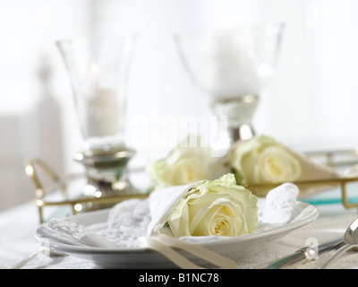 Deux lanternes de table et un lieu avec une rose blanche enveloppée d'une serviette Banque D'Images