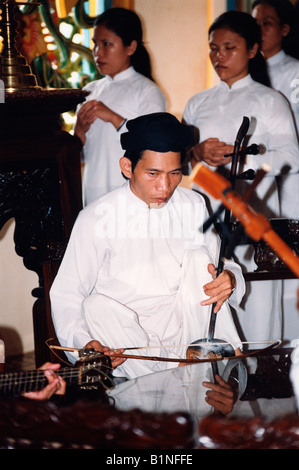 Vietnam homme jouant de l'instrument traditionnel vietnamien Grand Temple Caodai Tay Ninh Banque D'Images