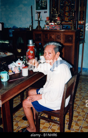 Delta du Mékong Vietnam vietnamien âgées homme boire le thé dans sa maison Banque D'Images