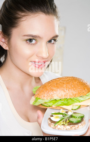 Jeune femme avec deux sandwichs Banque D'Images