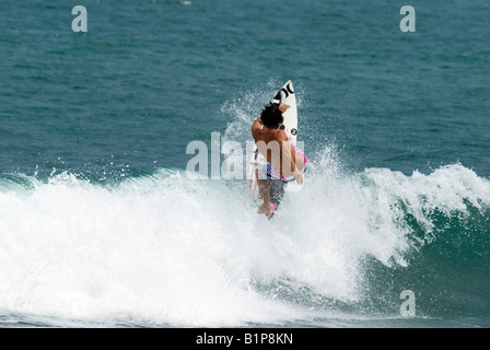 Pro surfer Kalani Robb du surf à Bali un gaucher bleu vert un émetteur d'ondes de la lip trick Banque D'Images